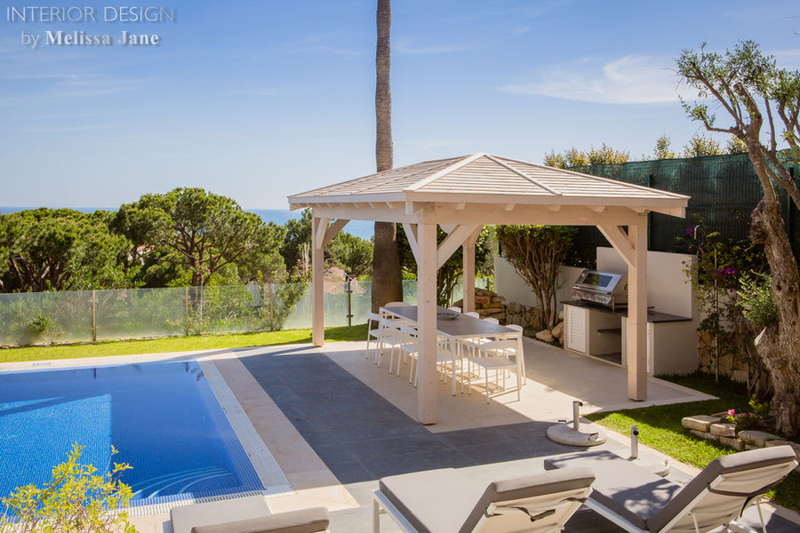 Outdoor kitchen and covered seating beside the pool