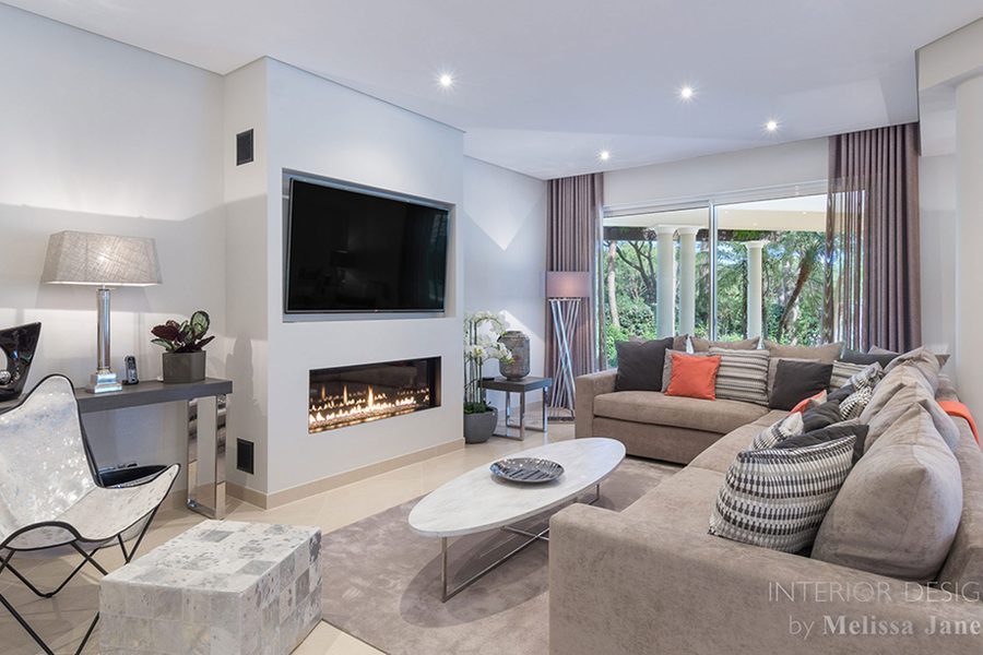 Living room with grey sofa, television wall and garden views