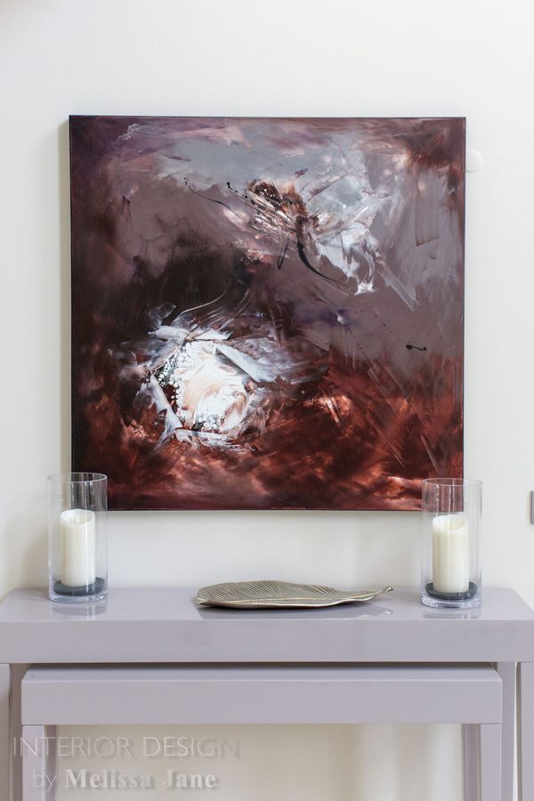 Console table with candles and tray beneath an abstract painting — Quinta Verde, Algarve