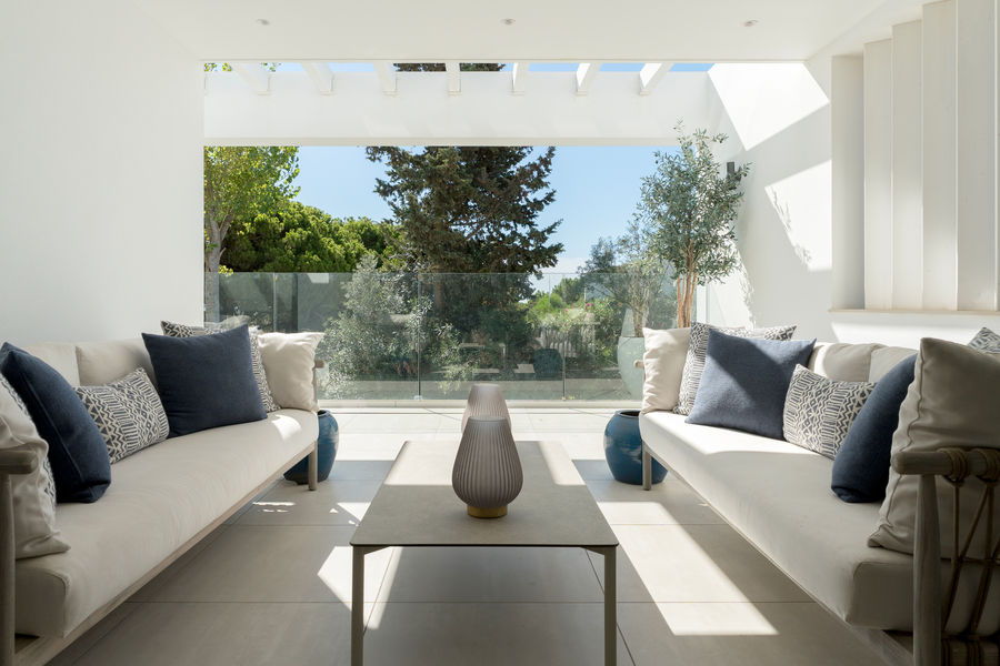 Garden-facing covered lounge with pale sofas