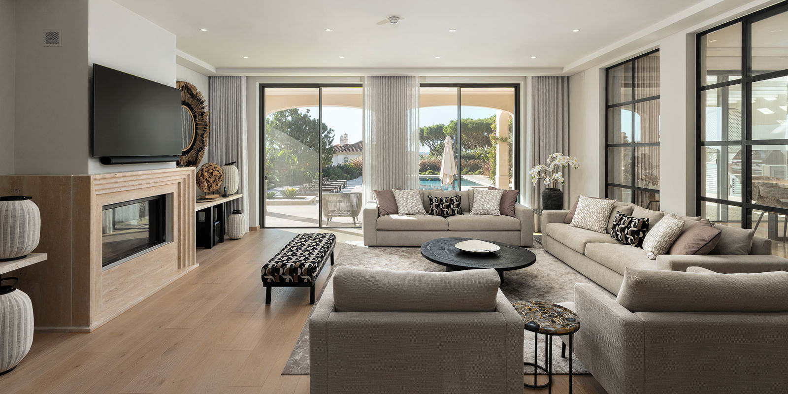 Relaxed living room by Melissa Jane Interiors with pool views