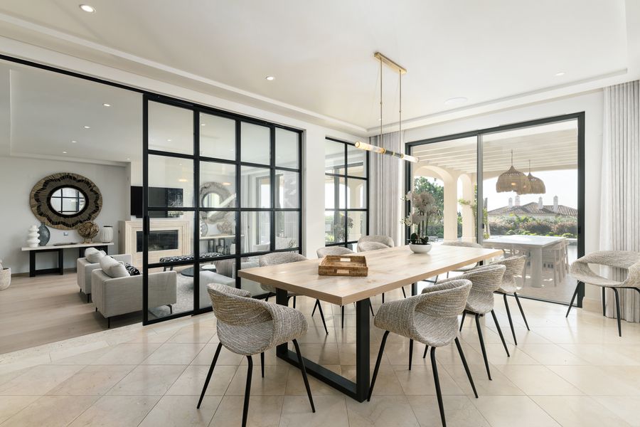 Dining area with garden views through black-framed doors — Dunas Douradas